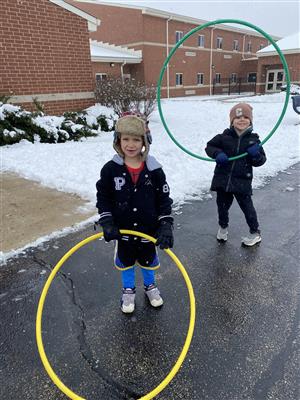 Students playing with hula hoops outside
