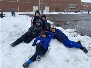 Students laying in the snow