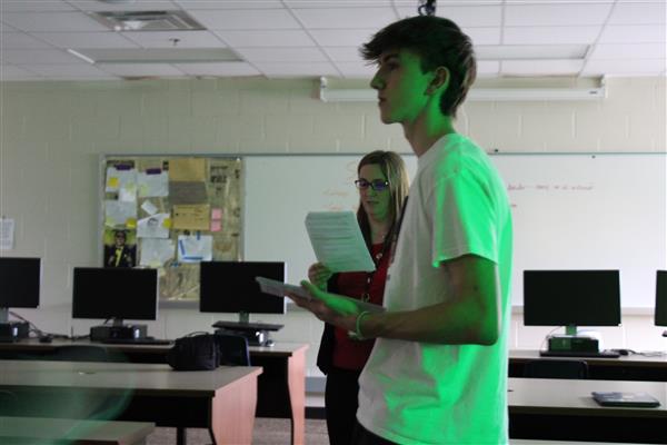 42Fifty Editor-in-Chief Brady Monahan and yearbook adviser Ewa Tulak took turns reading induction ceremony selections during the February 14, 2023, Quill & Scroll induction ceremony at Oswego High School.