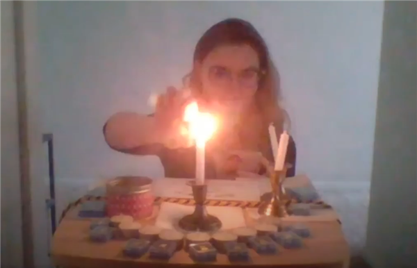 OHS Journalism Adviser Sarah Hands lights the induction candle for the 2020 Quill & Scroll Honor Society induction ceremony.