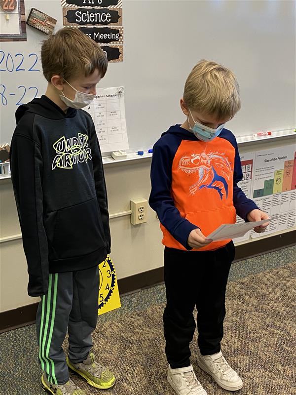 Mrs. Brougham's student reading his writing to his brother's 3rd grade class