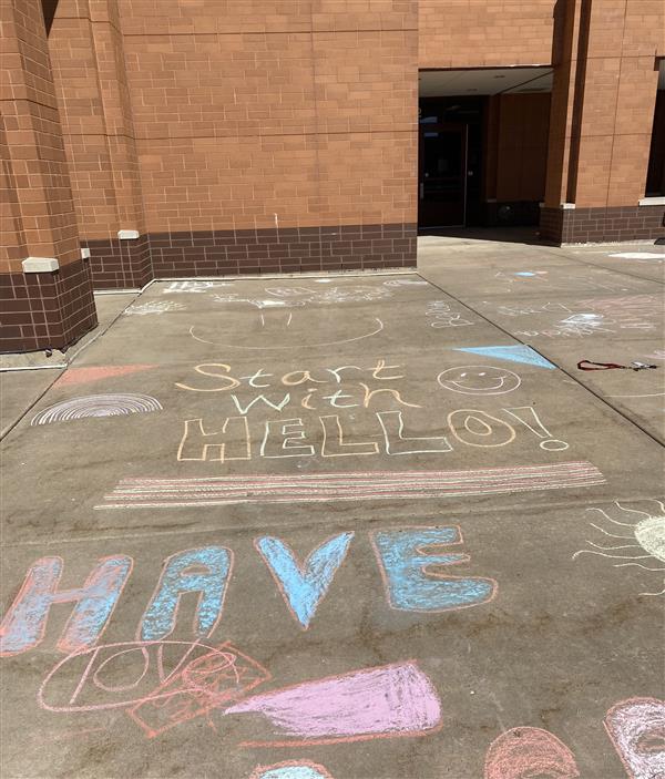 Messages written in chalk on the sidewalk.