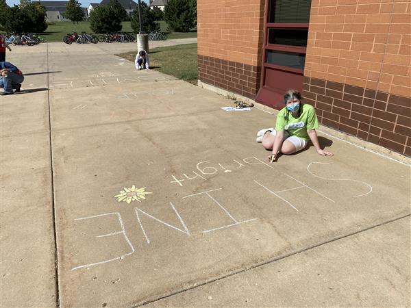 Student ambassador writes sidewalk messages