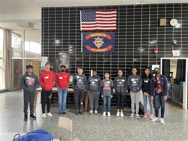 10 students pose under the Marmion Academy Banner