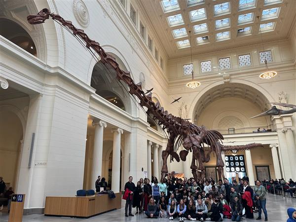 Students pose with Maximo, the large fossil replica at the Field Museum