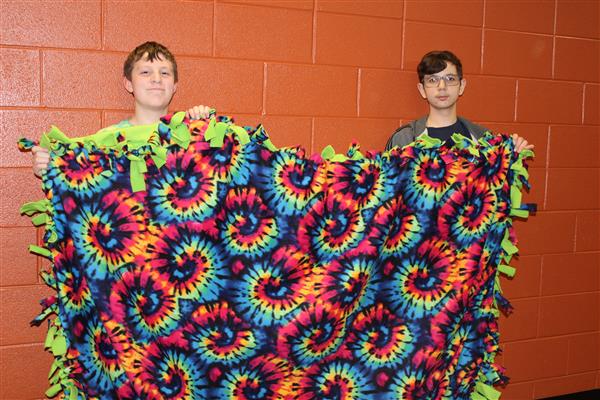2 boys hold up a blankety that they made