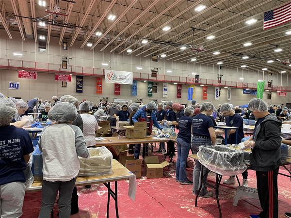 Large open space with groups of people packing up food