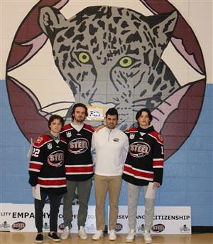 4 members of the Chicago Steel hockey team standing by the Jaguar in the Fox Chase gym