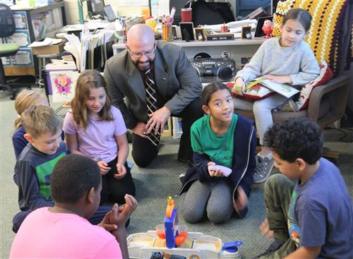 Dr. Sparlin watching students playing basketball