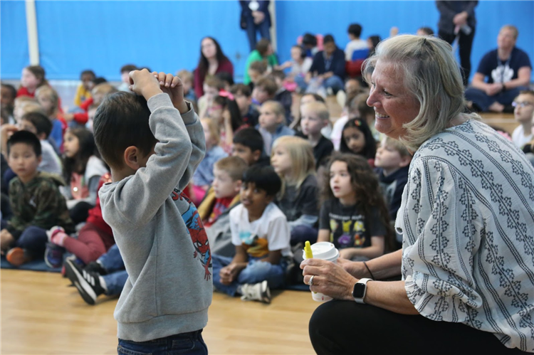 author with individual student with other students in the background