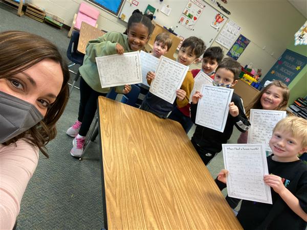 Mrs. Brougham's 1st grade sharing their writing with their kindergarten teacher and her class